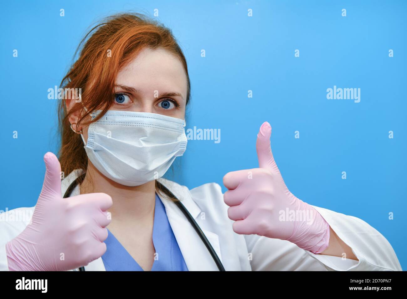 Doktor Hände in einem rosa medizinischen Handschuh, gibt einen Daumen - Geste der Zustimmung. Eine Krankenschwester in weißer Uniform macht eine Geste, dass alles in Ordnung ist Stockfoto