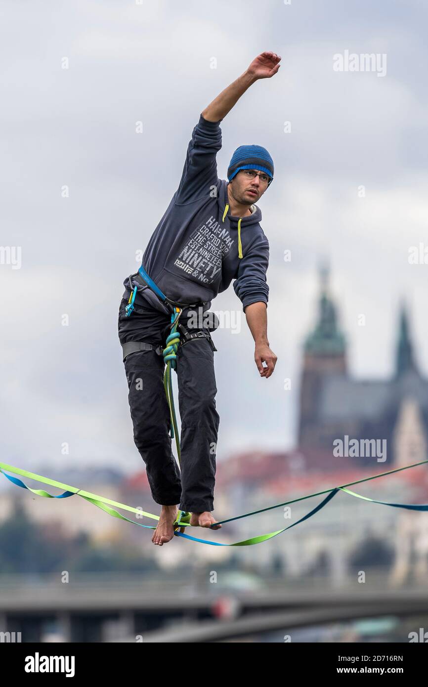 Ein Seiltänzer auf der Slacklinie über der Moldau mit Panorama auf die Prager Burg, Tschechische republik Stockfoto