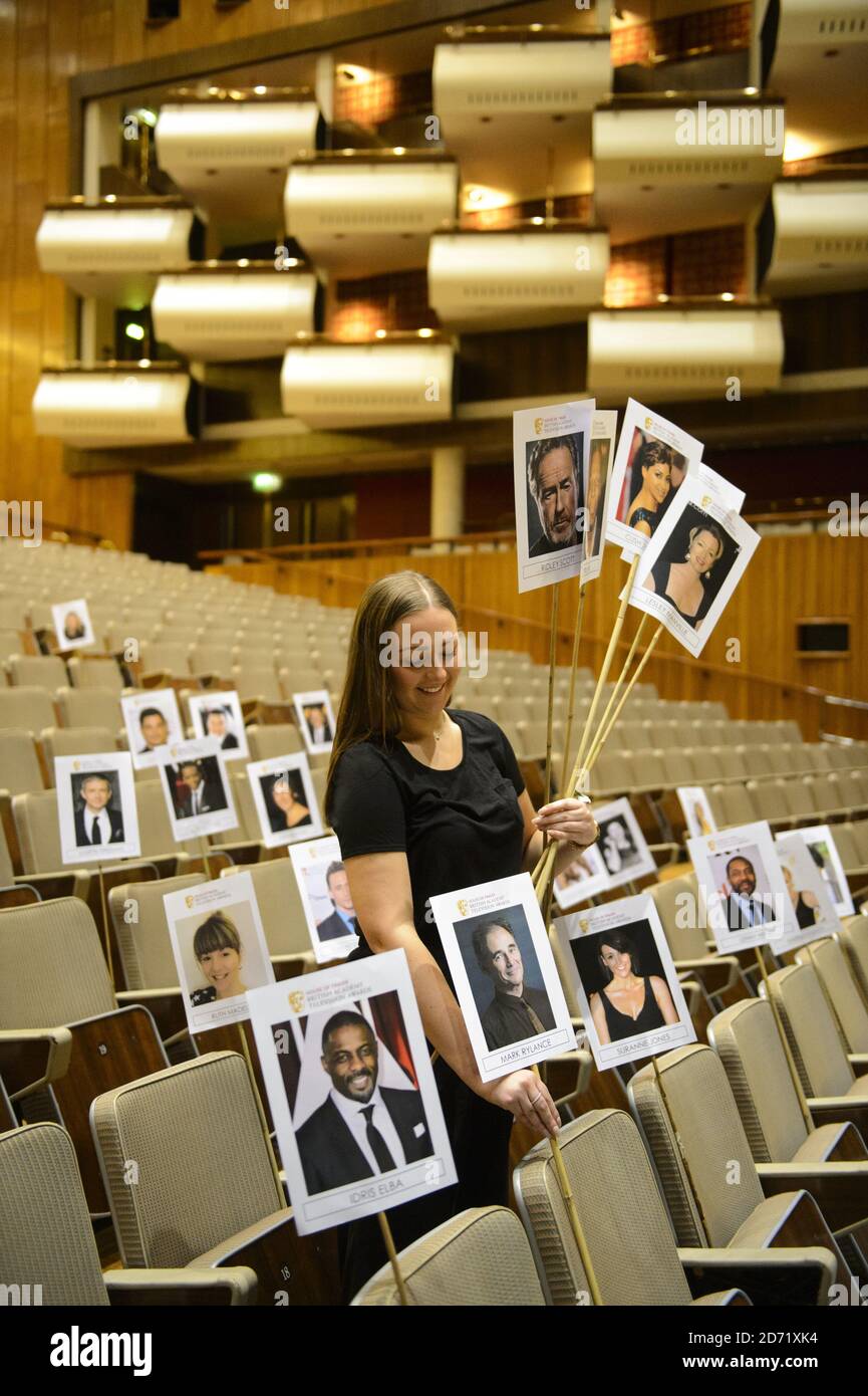 BAFTA-Mitarbeiterin Emily Holmes passt die Köpfe auf Stöcken an und zeigt den Sitzplan für Nominierte und Gäste bei den House of Fraser BAFTA TV Awards in der Royal Festival Hall, London. Stockfoto