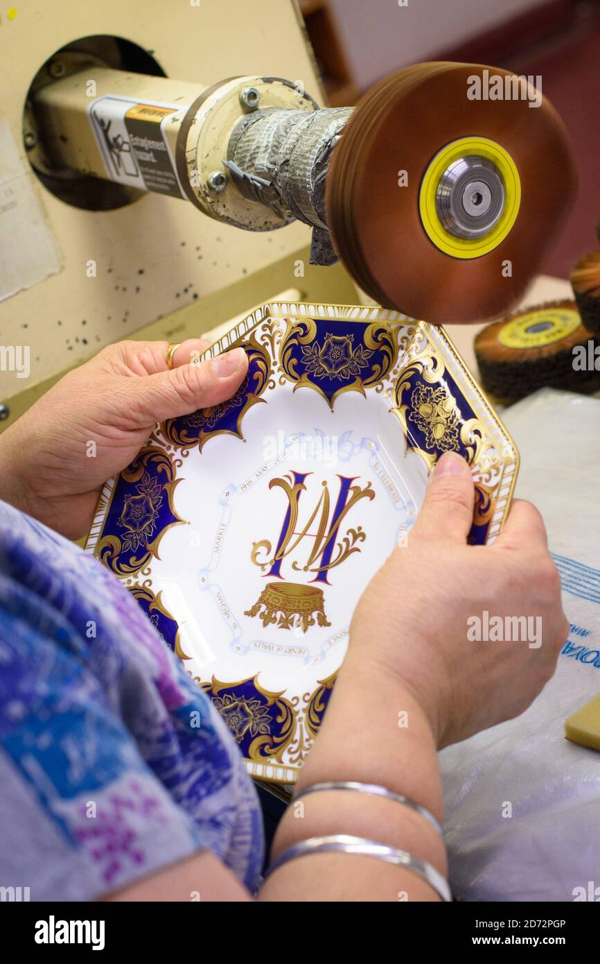 Ein Burnisher poliert das 22ct Gold auf einer achteckigen Platte, die die bevorstehende königliche Hochzeit in der Werkstatt von Royal Crown Derby in Derby, England, darstellt. Die Firma, die aus dem Jahr 1750 stammt, hat gerade ihre Gedenkstücke zu Ehren der königlichen Hochzeit zwischen Prinz Harry und Meghan Markle angekündigt. Royal Crown Derby's Bone china wird immer noch vollständig in Großbritannien hergestellt, wobei Techniken seit dem 18. Jahrhundert weitgehend unverändert verwendet werden. Bilddatum: Donnerstag, 19. April 2018. Bildnachweis sollte lauten: Matt Crossick/ EMPICS Entertainment. Stockfoto