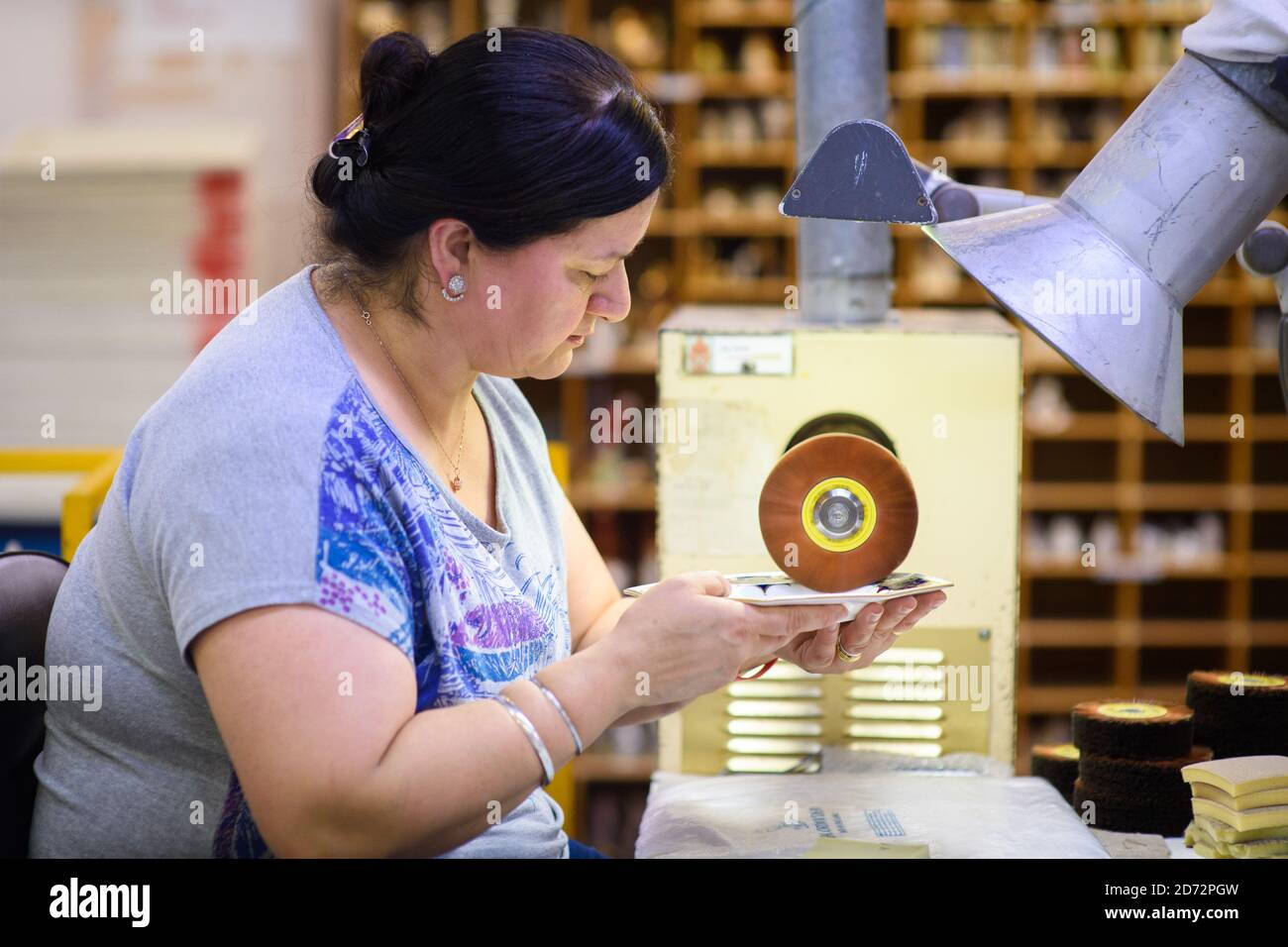 Ein Burnisher poliert das 22ct Gold auf einer achteckigen Platte, die die bevorstehende königliche Hochzeit in der Werkstatt von Royal Crown Derby in Derby, England, darstellt. Die Firma, die aus dem Jahr 1750 stammt, hat gerade ihre Gedenkstücke zu Ehren der königlichen Hochzeit zwischen Prinz Harry und Meghan Markle angekündigt. Royal Crown Derby's Bone china wird immer noch vollständig in Großbritannien hergestellt, wobei Techniken seit dem 18. Jahrhundert weitgehend unverändert verwendet werden. Bilddatum: Donnerstag, 19. April 2018. Bildnachweis sollte lauten: Matt Crossick/ EMPICS Entertainment. Stockfoto