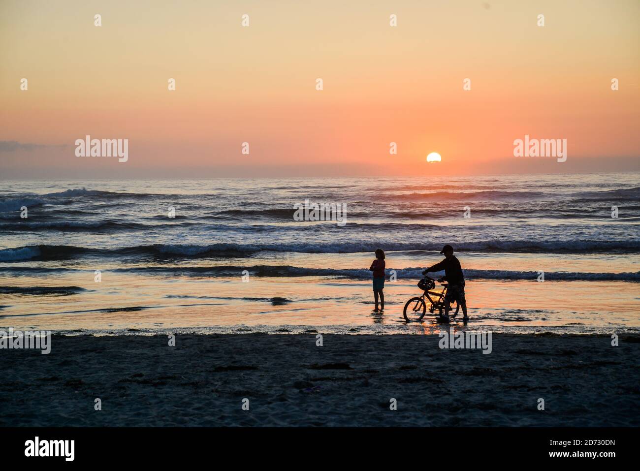 Sonnenuntergangssilhouetten am Cannon Beach, Küste von Oregon, Pazifischer Ozean, USA. Stockfoto