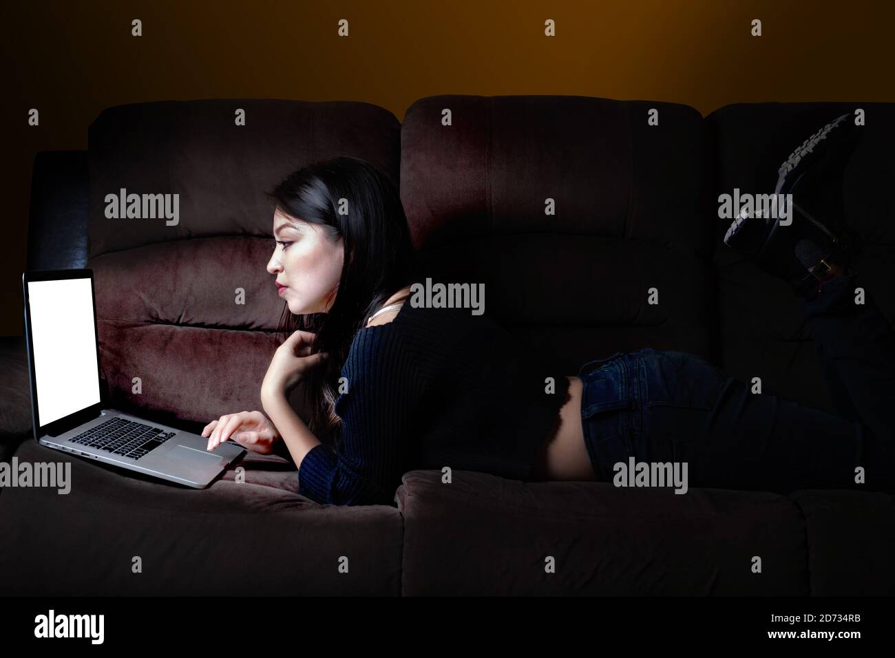 Junge Frau liegt im Video-Chat zu Hause Stockfoto