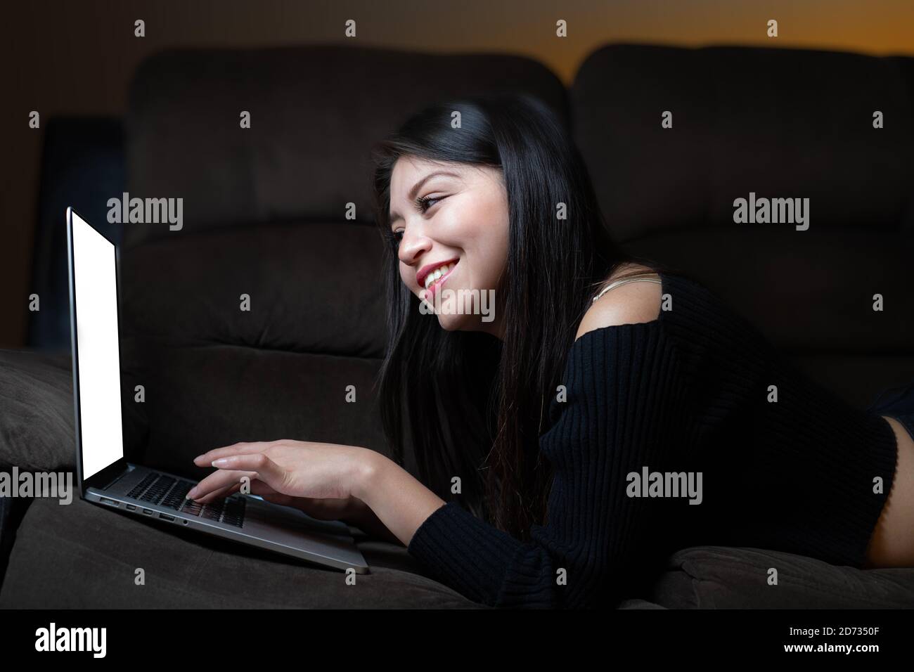 Junge Frau liegt im Video-Chat zu Hause Stockfoto