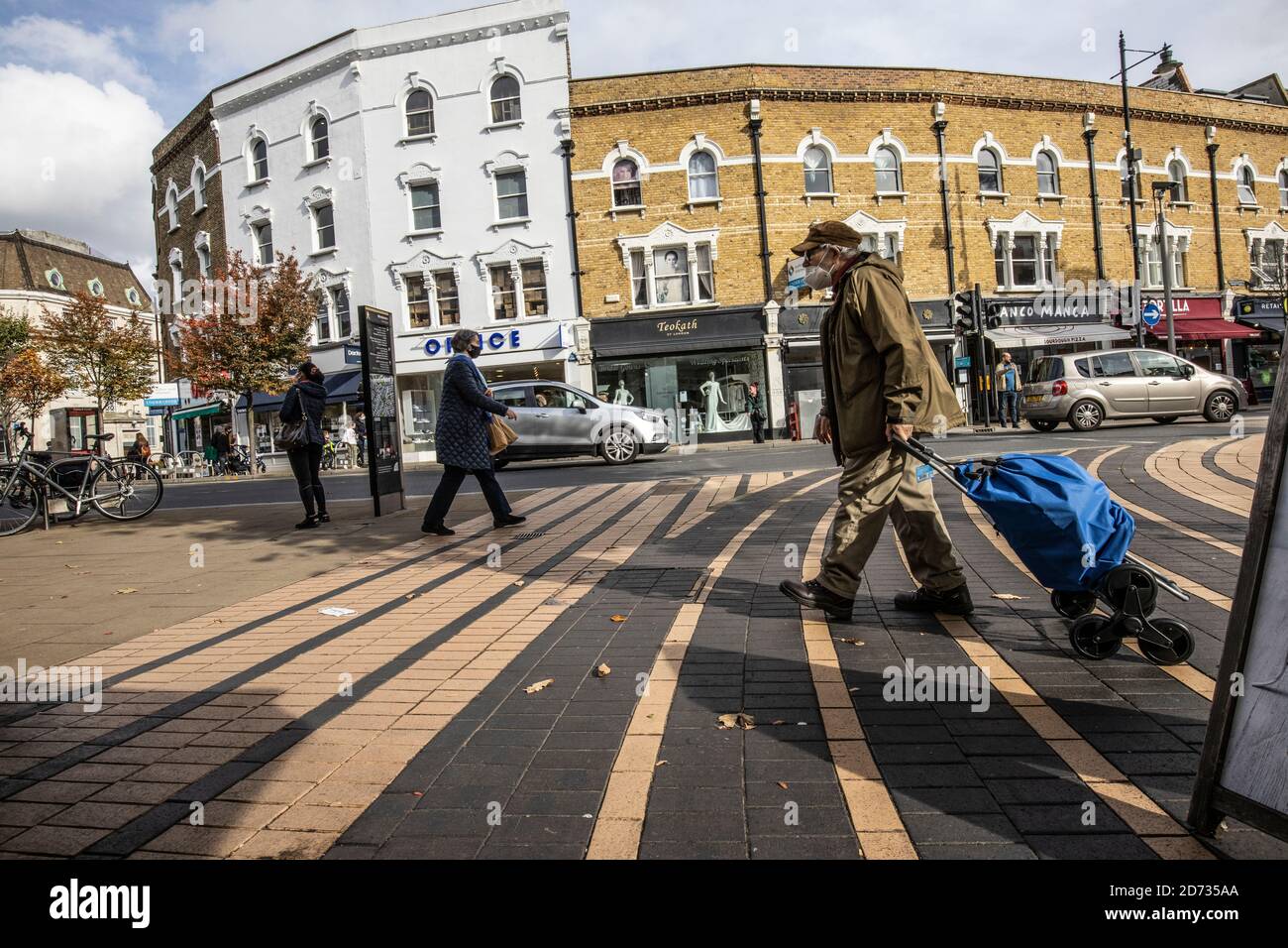 Obdachloser, der den Bürgersteig im Stadtzentrum von Wimbledon, Südwest-London, England, Großbritannien überquert Stockfoto