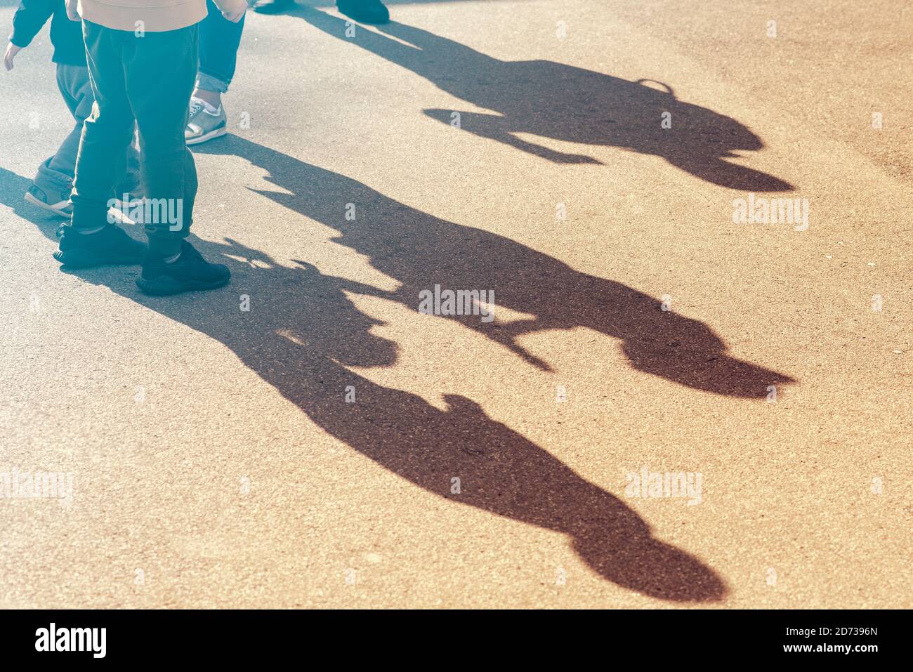 Kinder Silhouetten und Schatten auf Asphaltstraße, drei Kinder gehen in einer Straße Stockfoto