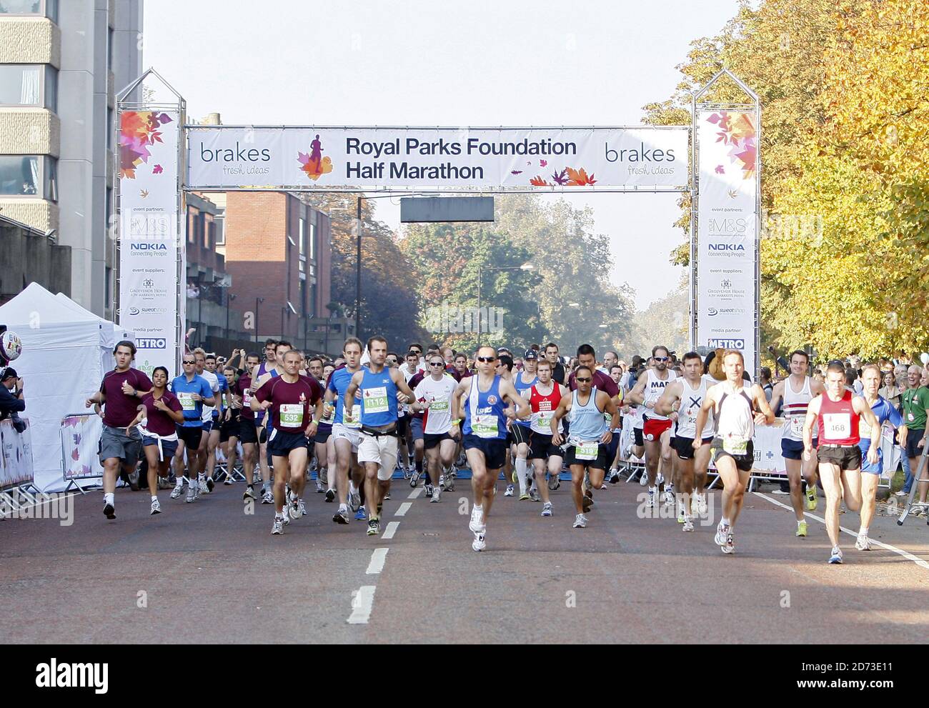 Beim Halbmarathon der Royal Parks Foundation in Hyde Park, London, überqueren die Teilnehmer die Startlinie. Über 10,000 Läufer liefen 13.1 Meilen durch vier Royal Parks und endeten beim Brakes Food and Fitness Festival im Hyde Park. Stockfoto