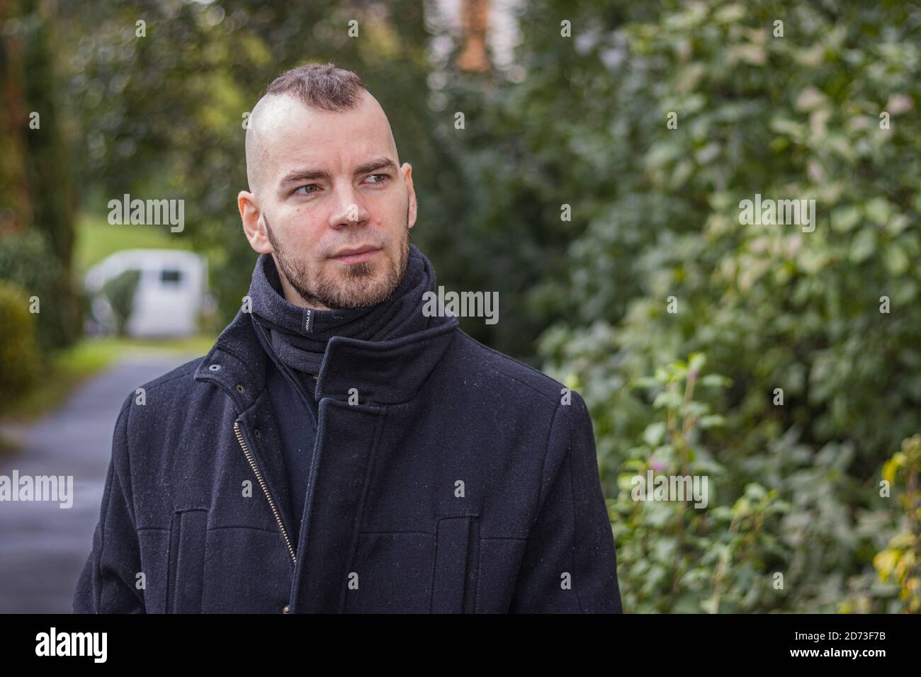 Ein Mann geht im tropfenden Regen in einem kleinen Stadt in Ungarn Stockfoto