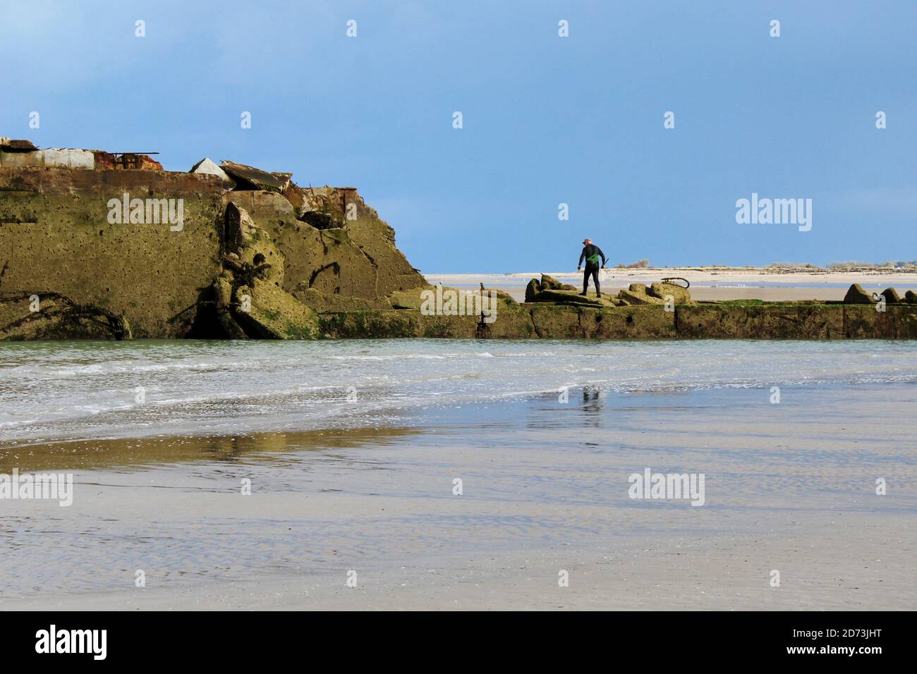 Ein Fischersmann an den Ruinen des Gold Beach, Frankreich, Normandie Stockfoto