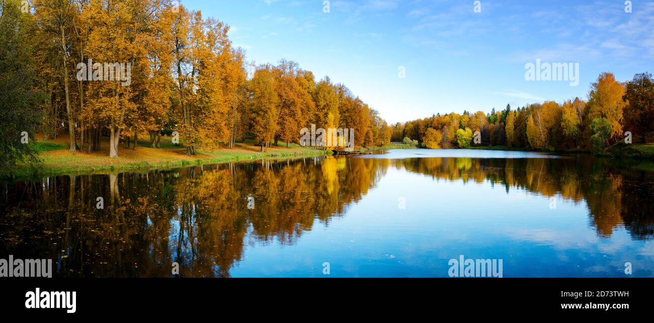 Schöne sonnige Herbstlandschaft mit ruhigem See im Park und Bäume mit gelbem Herbstlaub Stockfoto