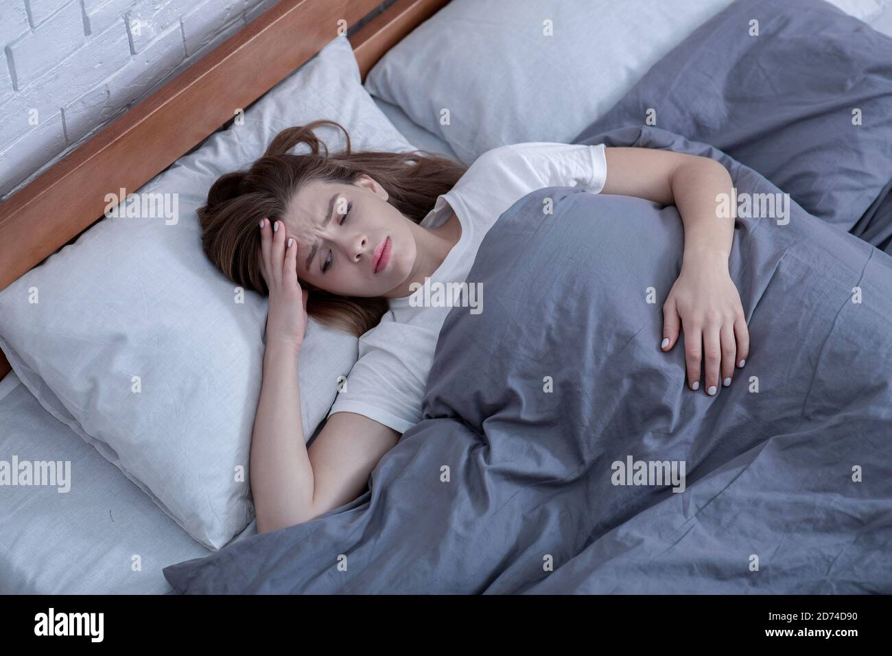 Psychologische Gesundheitsfürsorge. Traurige Dame, die allein im Bett liegt, an Depressionen leidet oder Schlafstörungen hat, Draufsicht Stockfoto