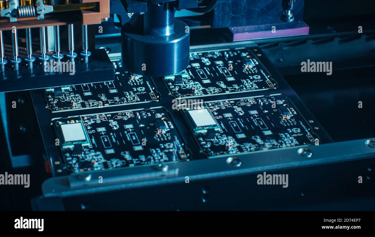 Makroaufnahme der Leiterplatte in einer Fabrik Montagelinie mit automatisiertem Roboterarm für SMD-Mikroprozessoren Zum Stockfoto