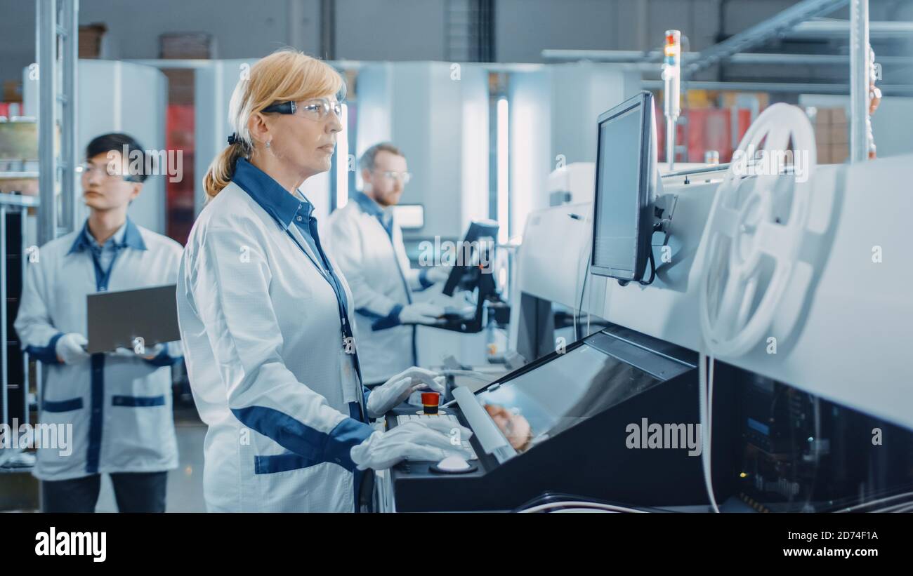 In der High-Tech-Fabrik verwendet eine Ingenieurin Computer für die Programmierung Pick and Place Elektronische Maschinen für Leiterplatten Oberfläche Montieren Sie Die Baugruppe Stockfoto