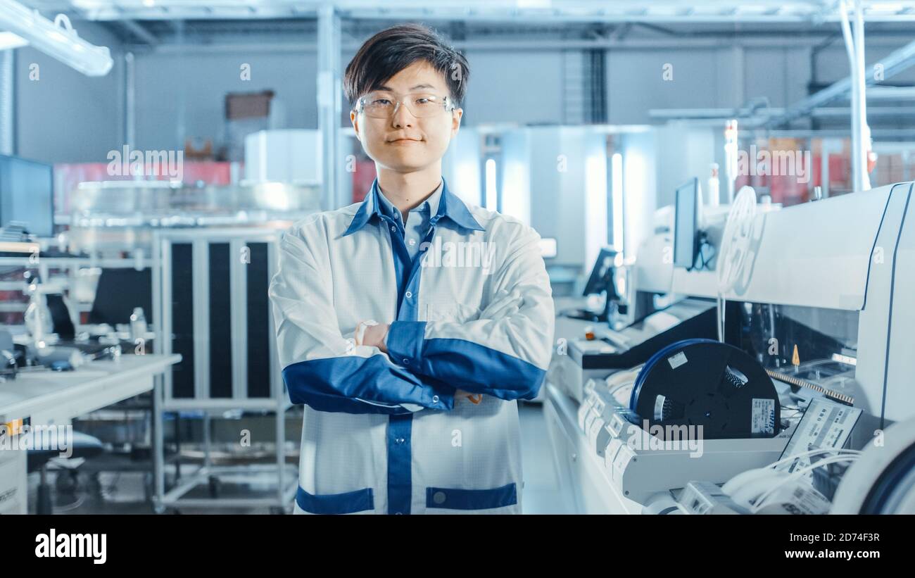 Auf High-Tech Factory: Portrait of Asian Worker with Crossed Arms. In der Baulinie für elektronische Leiterplatten im Hintergrund, die Oberfläche verwendet Stockfoto