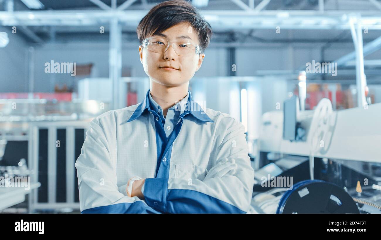Auf High-Tech Factory: Portrait of Asian Worker with Crossed Arms. In der Baulinie für elektronische Leiterplatten im Hintergrund, die Oberfläche verwendet Stockfoto