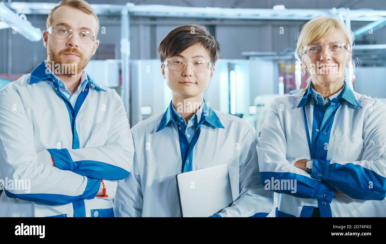 Auf High-Tech Factory: Portrait von drei professionellen Ingenieuren. In der Baulinie für elektronische Leiterplatten im Hintergrund, die Oberfläche verwendet Stockfoto