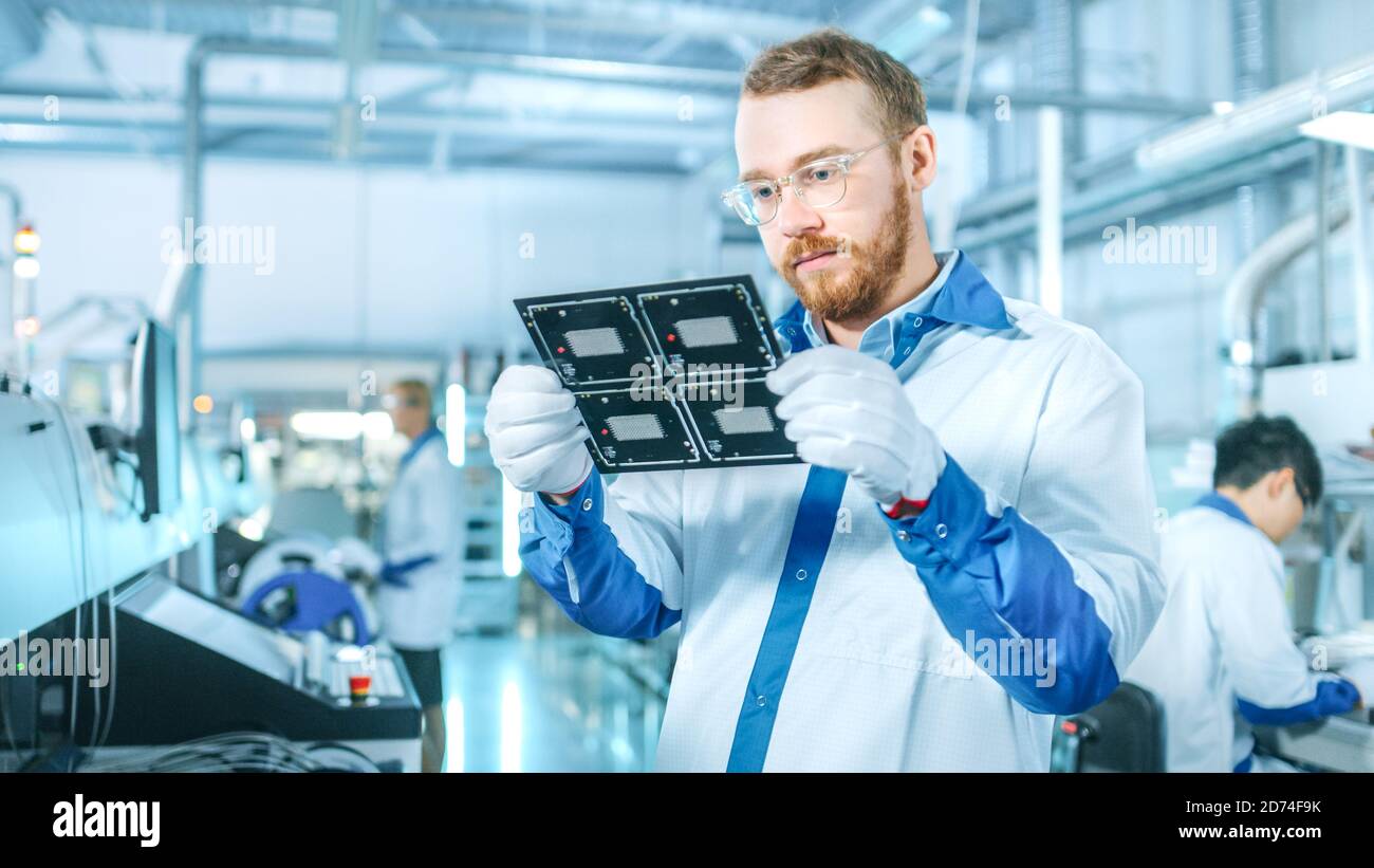 High-Tech Factory: Qualitätskontrolle Inspektor prüft elektronische Leiterplatten-IT auf Schäden. In der Background Assembly Line für Leiterplatte mit Stockfoto