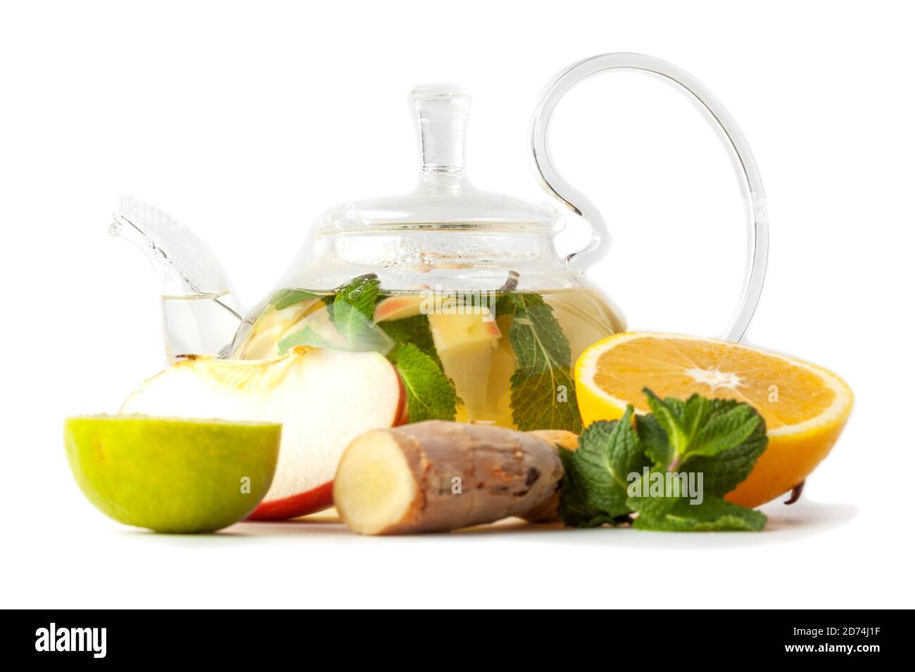 Isolierte transparente Teekanne aus Glas mit Tee aus Ingwerwurzel, Limette, Orange, Apfel, Minze Stockfoto