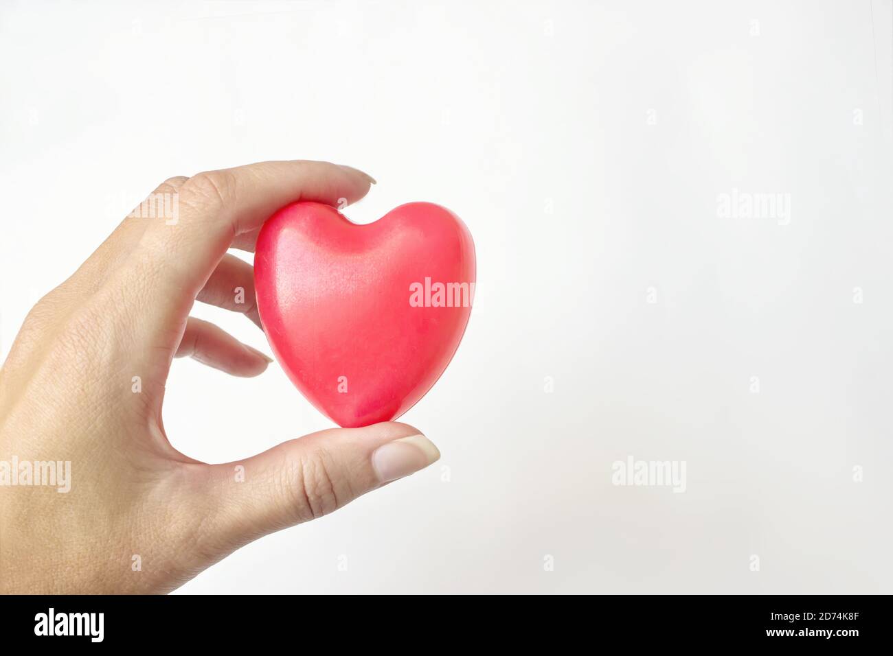 Frau Hand halten rote Herz auf dem weißen Hintergrund. Krankenversicherung, Spende, Lebensretterkonzept. Welt Herz Gesundheit Tag Idee Stockfoto