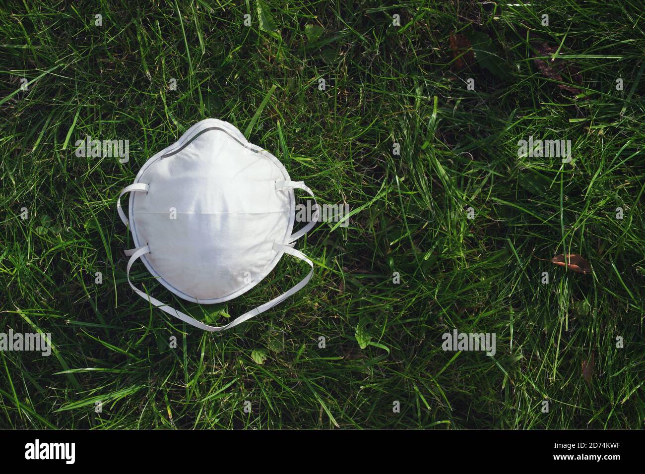 Coronavirus Gesichtsmaske auf grünem Gras, Gesundheitskonzept, Kopierraum Stockfoto