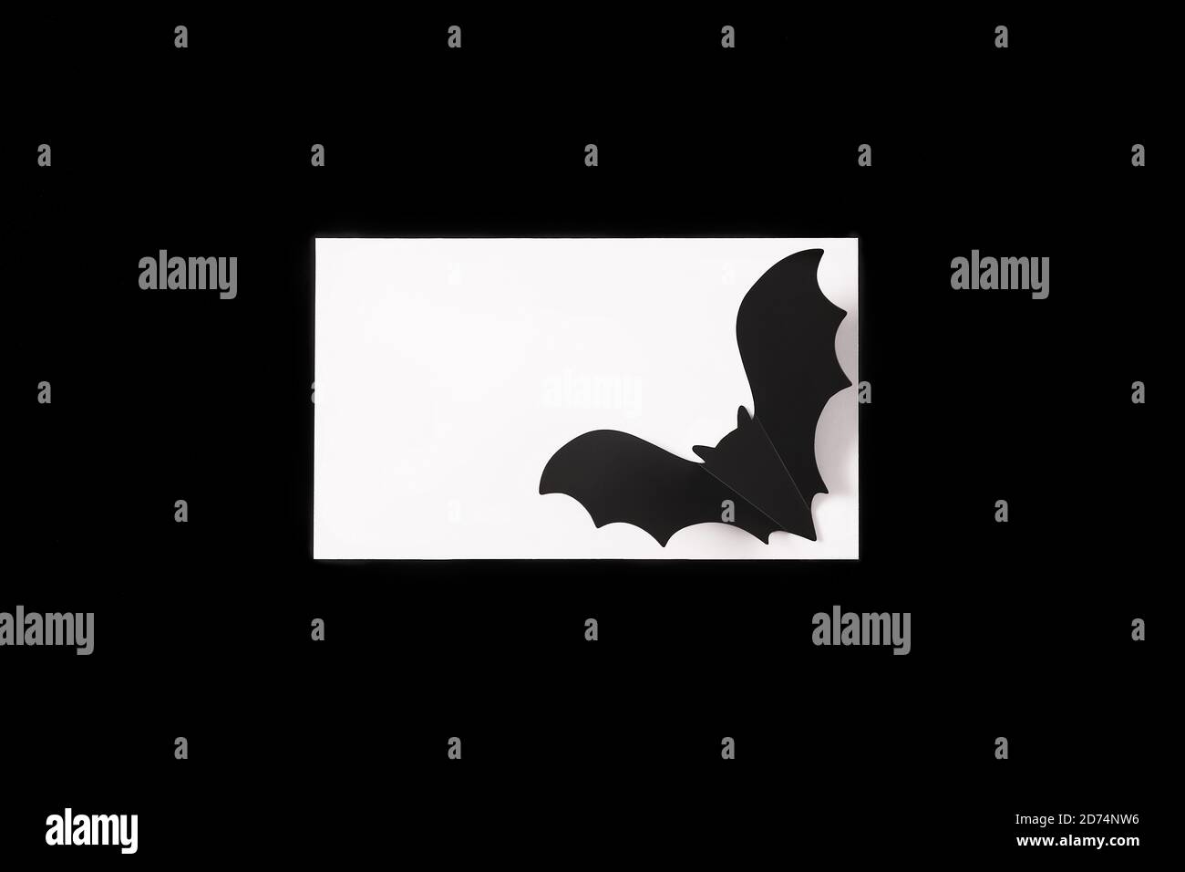 Cartoon Halloween Hintergrund weißes Papier leer mit schwarzer Fledermaus Silhouette auf schwarzem Hintergrund. Speicherplatz kopieren. Flache Lay-Optik. Halloween abstrakter Hintergrund. Schwarzer und weißer Hintergrund im dunklen Retro-Stil. Stockfoto