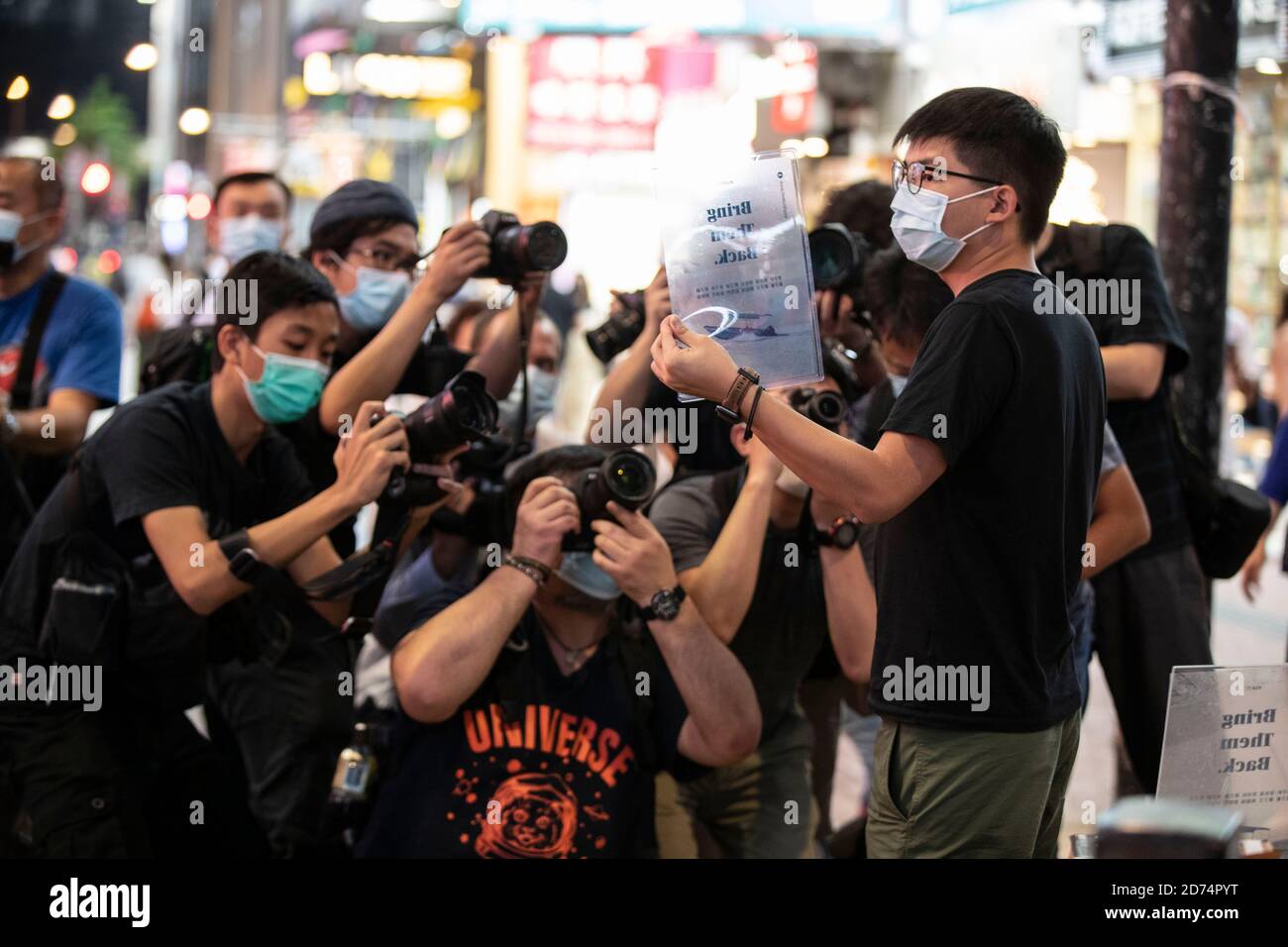 Hongkong, China. Oktober 2020. Medienmitarbeiter machen Fotos mit Joshua Wong, als er am 20. Oktober 2020 in Hongkong am 20. Oktober 2020 Transparenzkarten mit dem Titel „Bring them Back“ hält. Pro-demokratische Aktivisten, darunter Joshua Wong, gingen auf die Straße, um eine Online-Versammlung zur Unterstützung der 12 Hongkonger anzukündigen, die im August 2020 in China inhaftiert waren, nachdem sie angeblich versucht hatten, nach Taiwan zu fliehen.Quelle: May James/ZUMA Wire/Alamy Live News Stockfoto