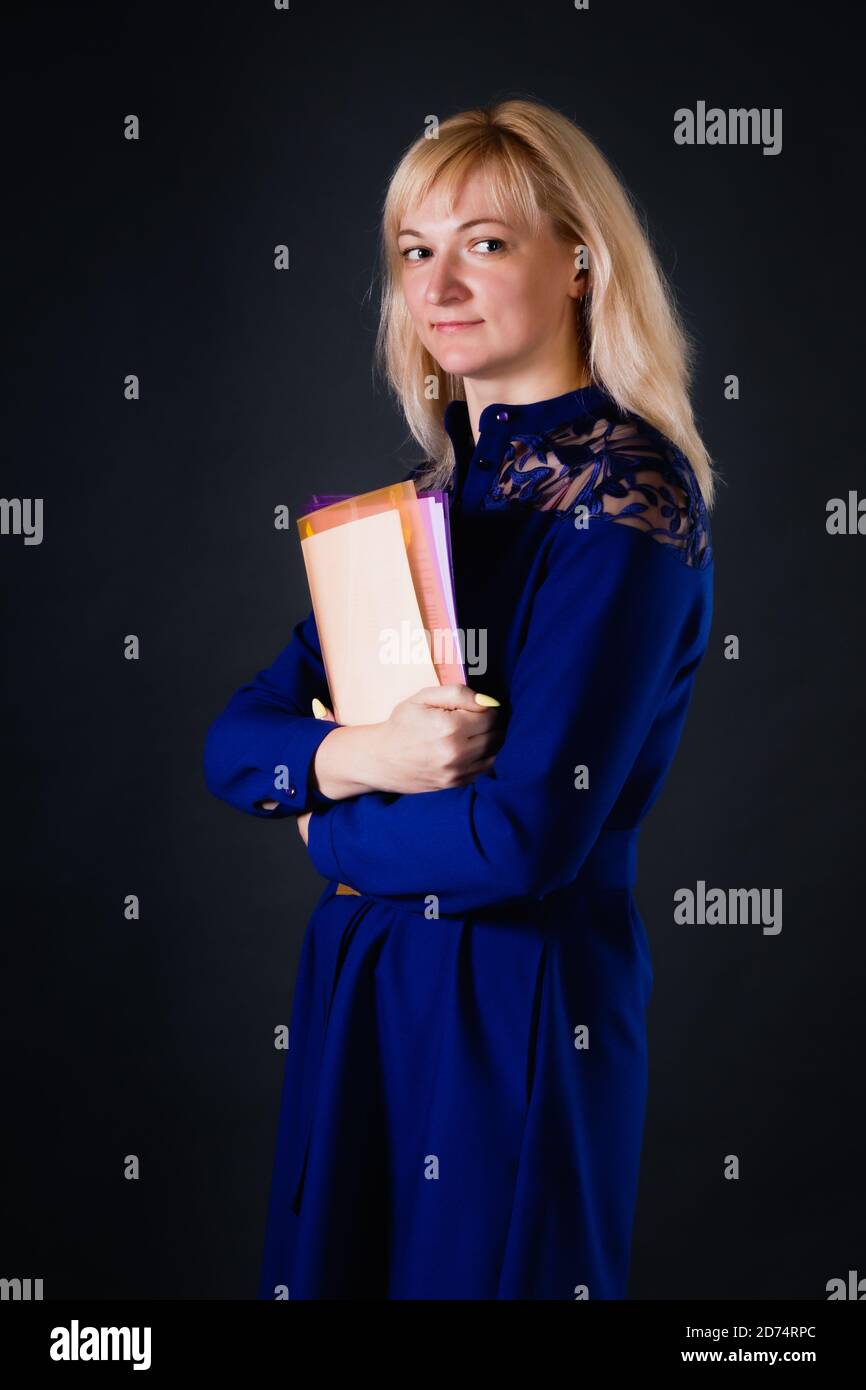 Selbstbewusste blonde Frau mit Dokumenten in ihren Händen Stockfoto
