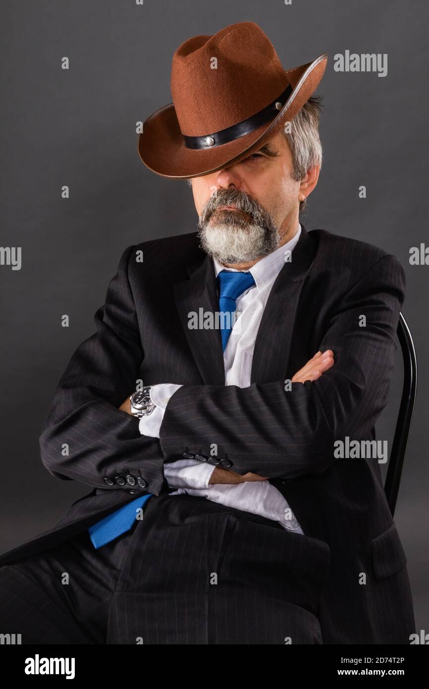 Ein schlafender Mann in einem Anzug mit Krawatte lehnte sich Zurück in seinem Stuhl und bedeckte sich mit einem Cowboy hut Stockfoto