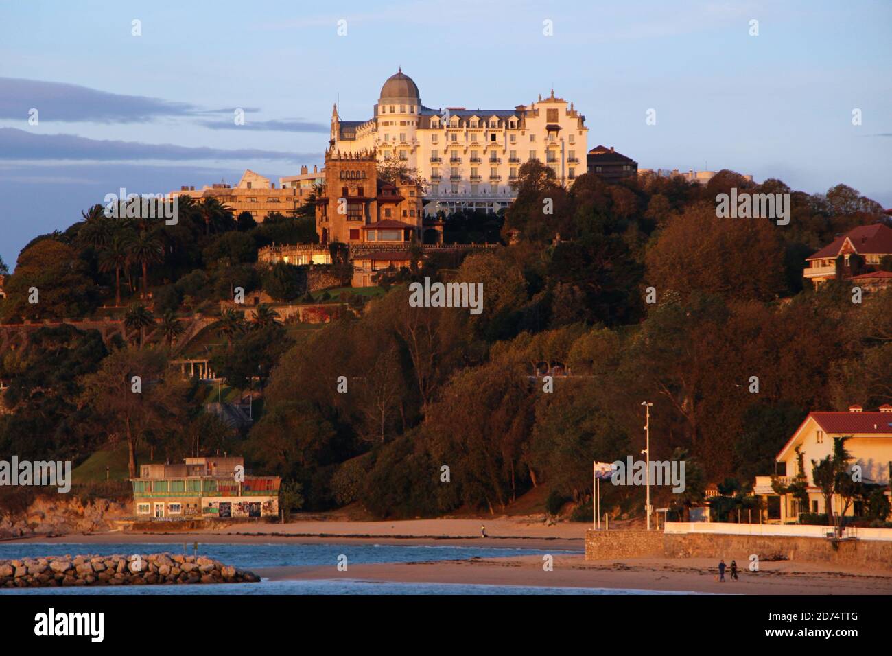 Das Hotel Real liegt am frühen Morgen auf einem Hügel Orangefarbenes Sonnenlicht von der Playa de los Bikinis Magdalena aus gesehen Halbinsel Santander Kantabrien Spanien Stockfoto