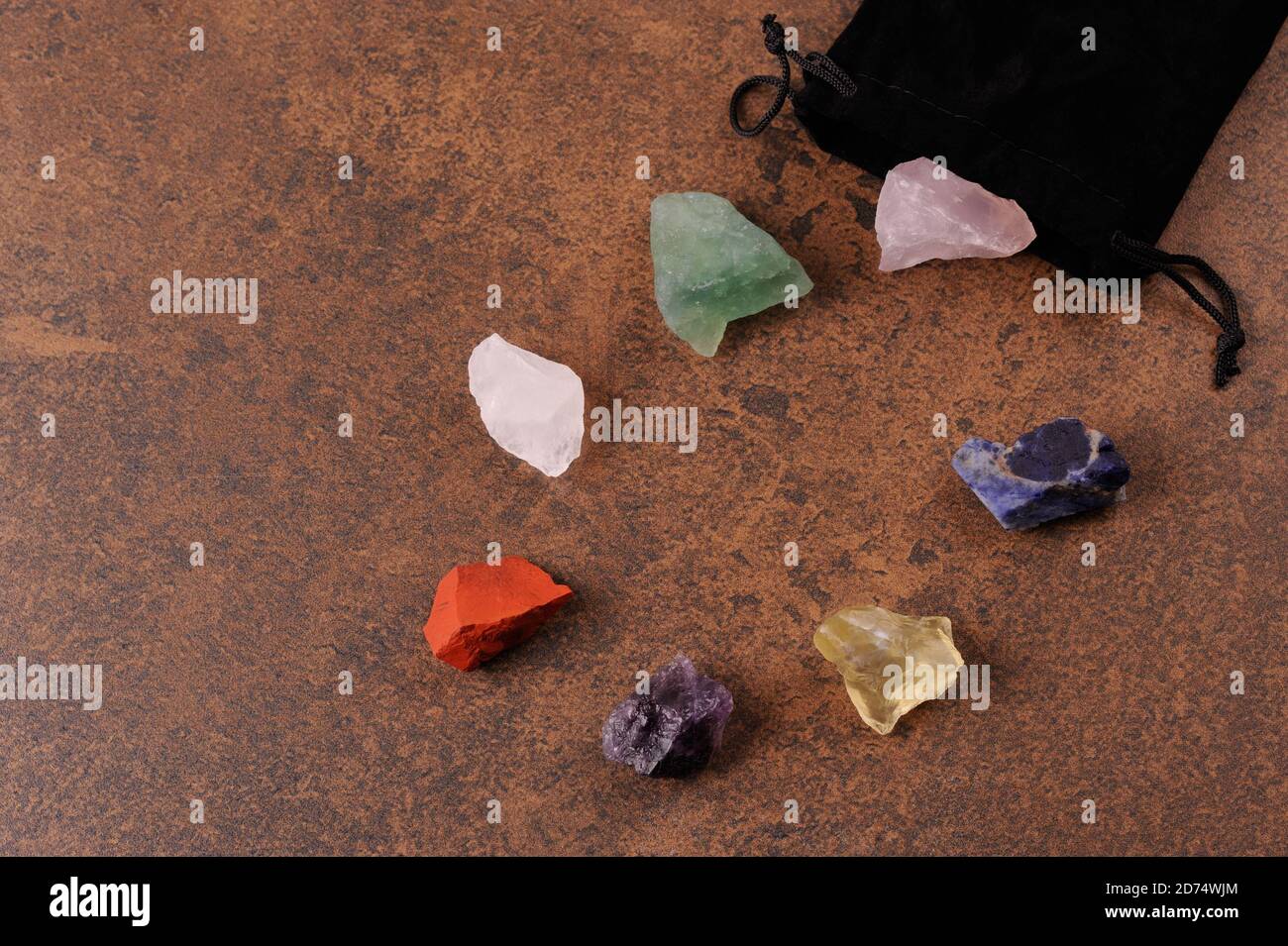 Set aus sieben heilenden Chakra-Mineralsteinen zur Kristallheilung. Chakra-Kristalle. Beutel mit bunten Steinen zur Aktivierung der Resonanz zwischen der st Stockfoto