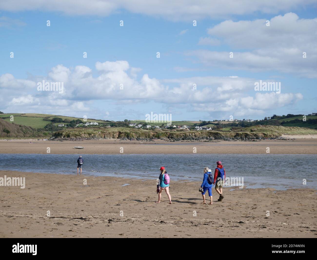 Menschen, die am Strand von Bigbury on Sea, Devon, Großbritannien, spazieren gehen Stockfoto