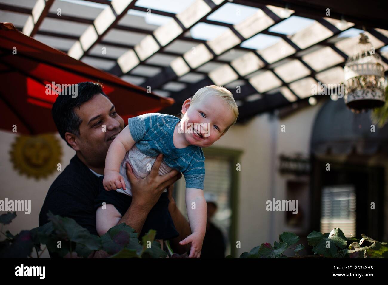 Onkel hält Neffen im vorderen Hof in San Diego Stockfoto
