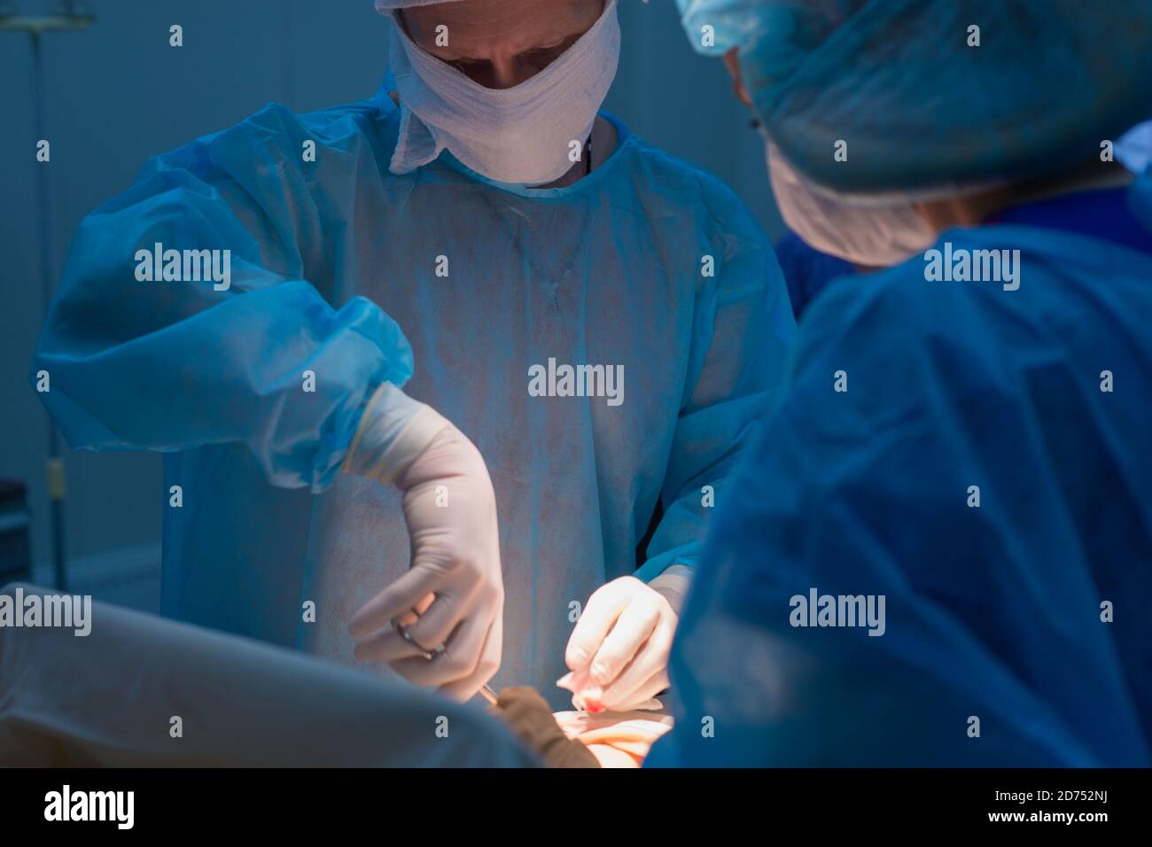 Chirurgen Kinder urologische Operationen durchführen. Ein Mann und eine Frau in einer Maske und einem blauen sterile Mantel in den Operationssaal. Ein Team von Chirurgen ist Co Stockfoto