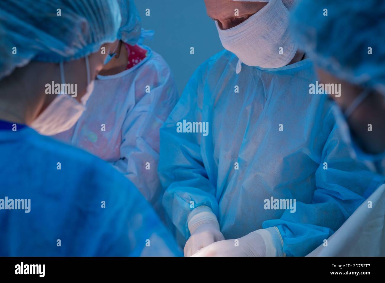 Chirurgen Kinder urologische Operationen durchführen. Ein Mann und eine Frau in einer Maske und einem blauen sterile Mantel in den Operationssaal. Ein Team von Chirurgen ist Co Stockfoto