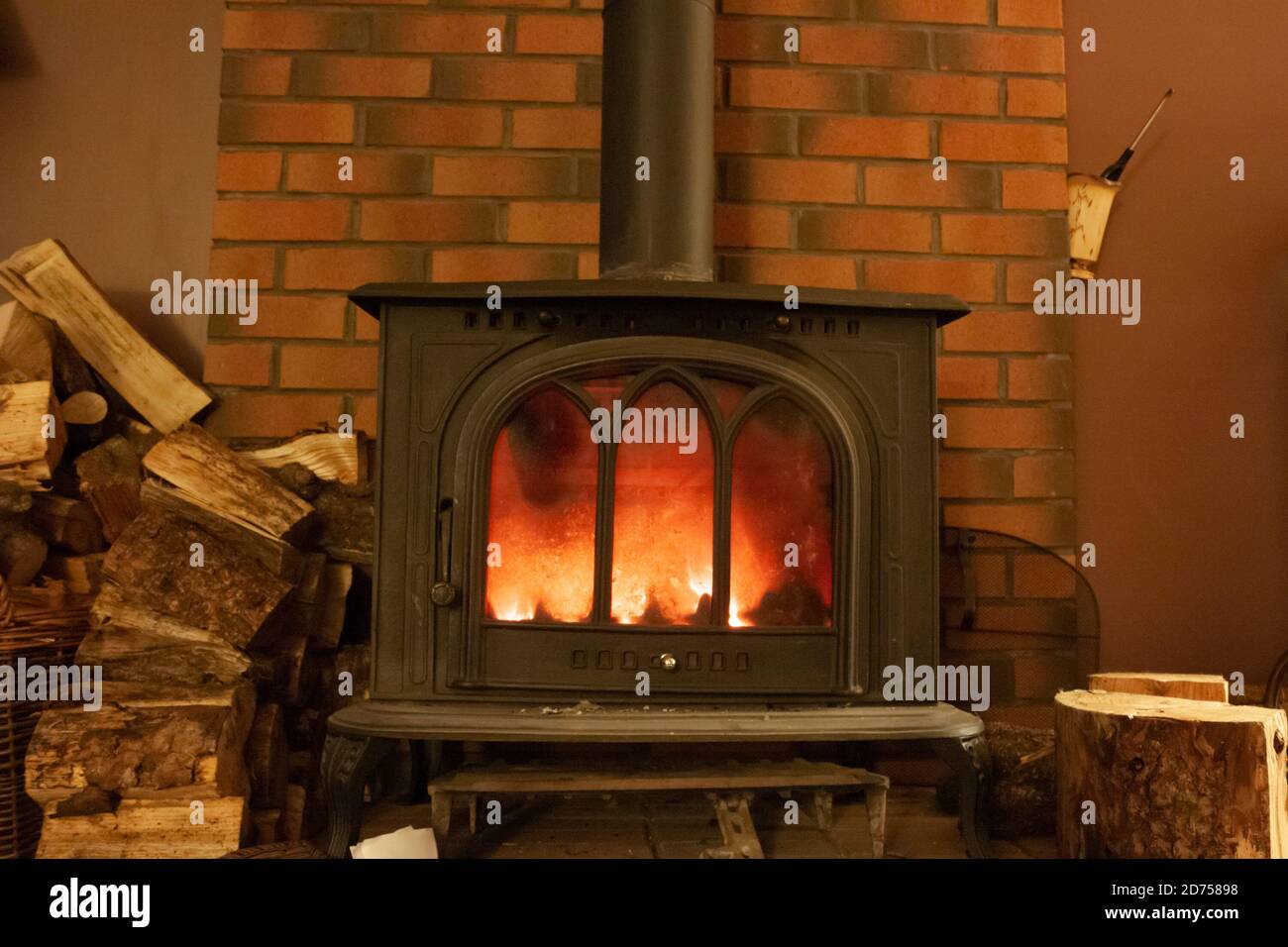 Holzofen und Holzstapel auf einem Herd mit einem Feuerstein zurück in einem privaten Haus, Schottland Großbritannien Stockfoto
