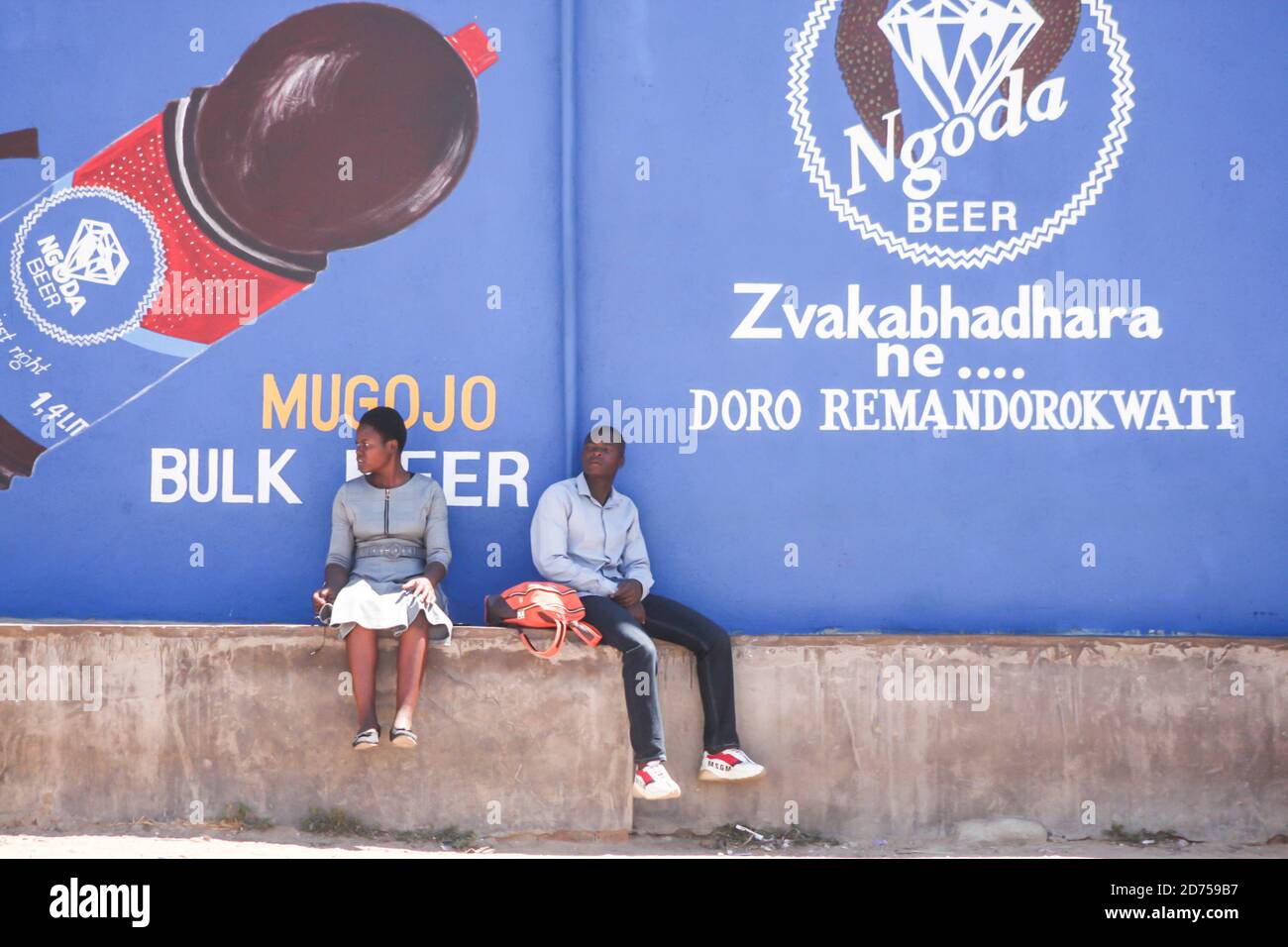 Ein Paar entspannt sich vor einem Geschäft. Die meisten Simbabwer haben jetzt begonnen, einige covid 19 Protokolle zu ignorieren, da viele Menschen sich jetzt frei ohne Masken bewegen. Harare, Simbabwe. Stockfoto