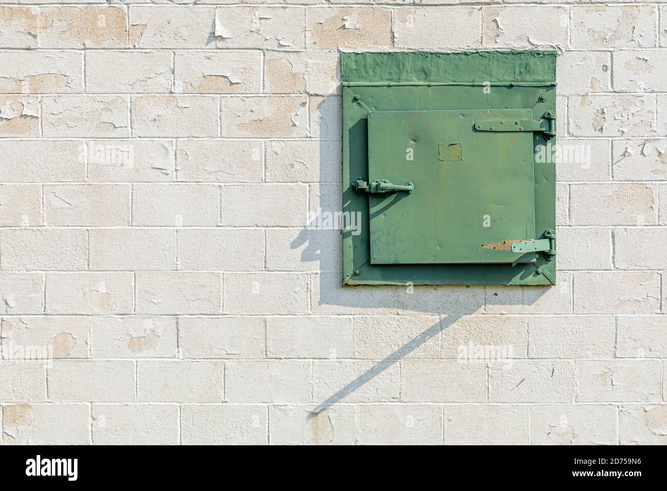 Alte grüne Metalltür in einer Betonblockwand Stockfoto