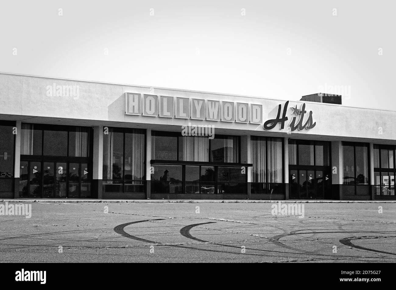 Ein Hollywood Hits Kino steht als Opfer des sich verändernden Medienkonsums und der Pandemie von 2020 vakant. Der massive Parkplatz ist jetzt verletzt Stockfoto