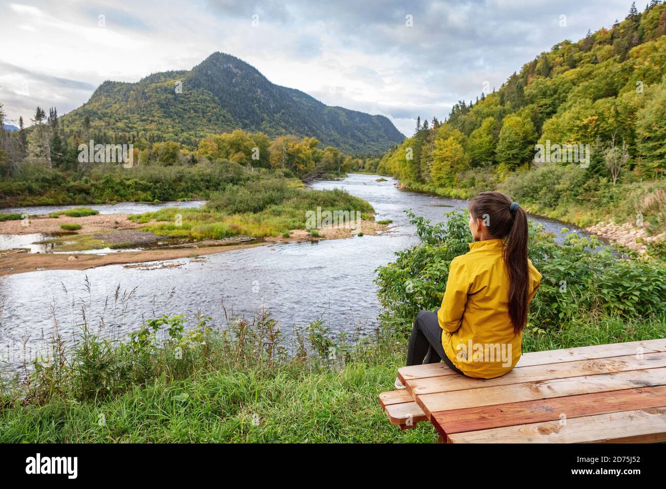 Camping Natur Frau sitzt am Picknicktisch genießen Blick auf Wildnis Fluss in Quebec und Herbst Laubwald, Kanada reisen. Parc de la Jacques Stockfoto