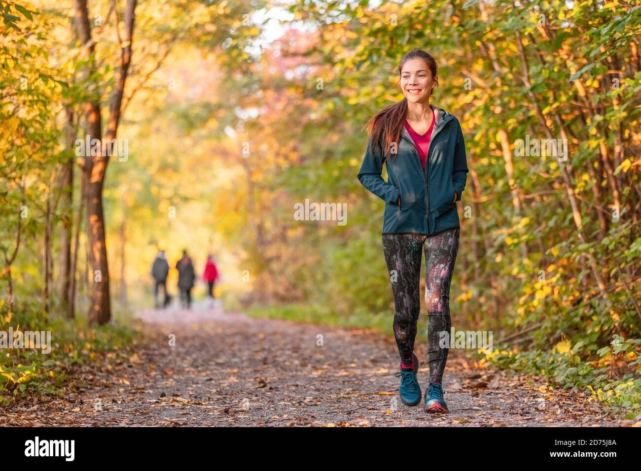 Frau zu Fuß im Herbst Wald Naturpfad Spaziergang auf Trail Wald Hintergrund. Glückliches Mädchen auf aktive Outdoor-Aktivität entspannen Stockfoto