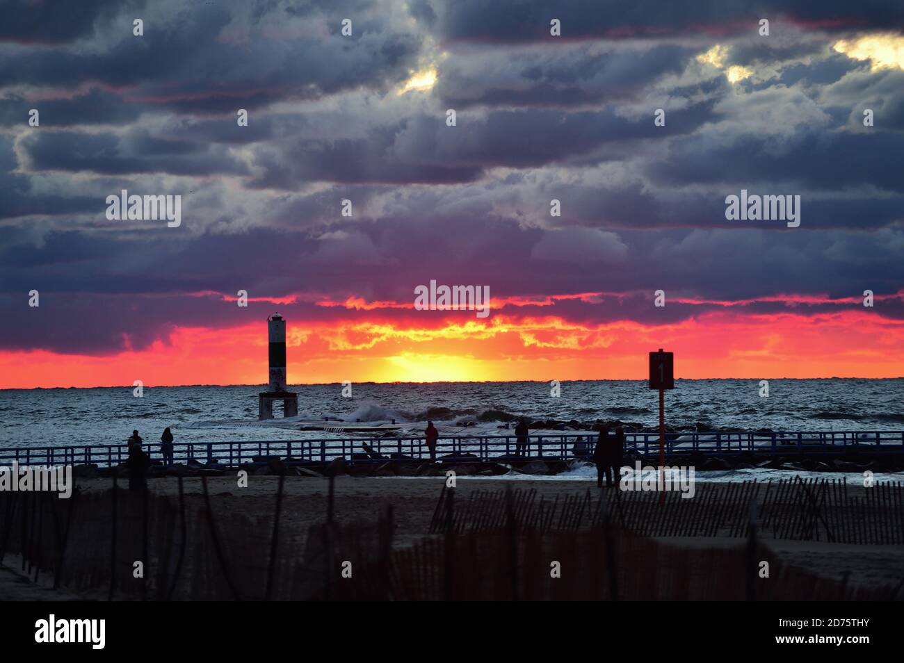 Holland, Michigan, USA. Die Sonne untergeht unter dem Horizont und Lake Michigan hinterlässt ein Leuchten, wie aus dem Holland, Michigan Strand gesehen. Stockfoto