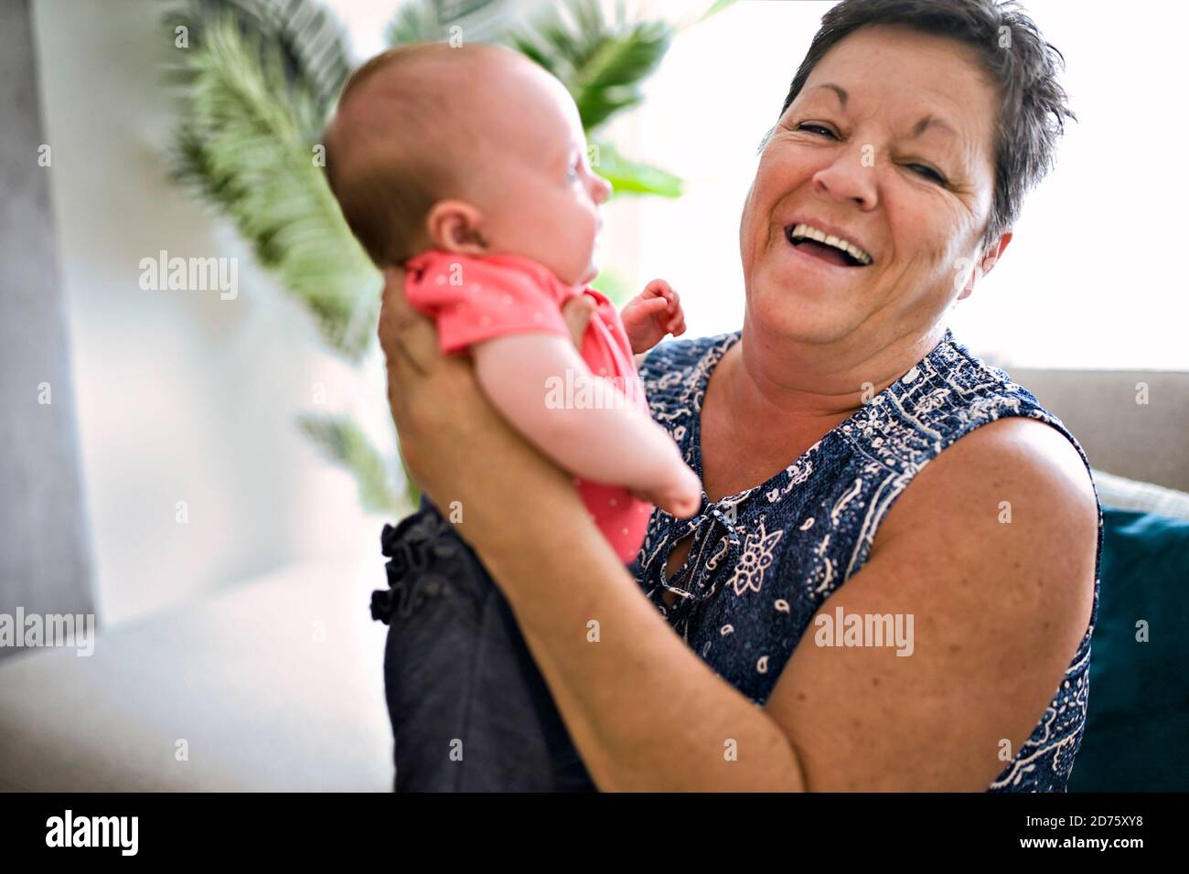 Großmutter auf dem Sofa mit Baby zu Hause Stockfoto