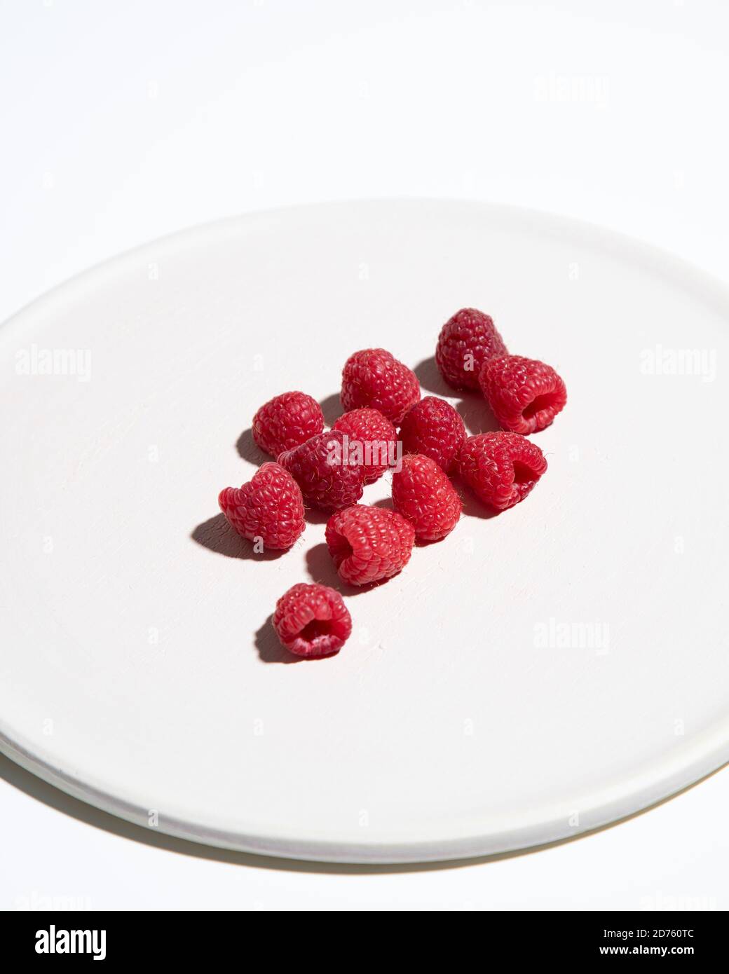 Himbeeren auf 3/4-weißem Teller Stockfoto