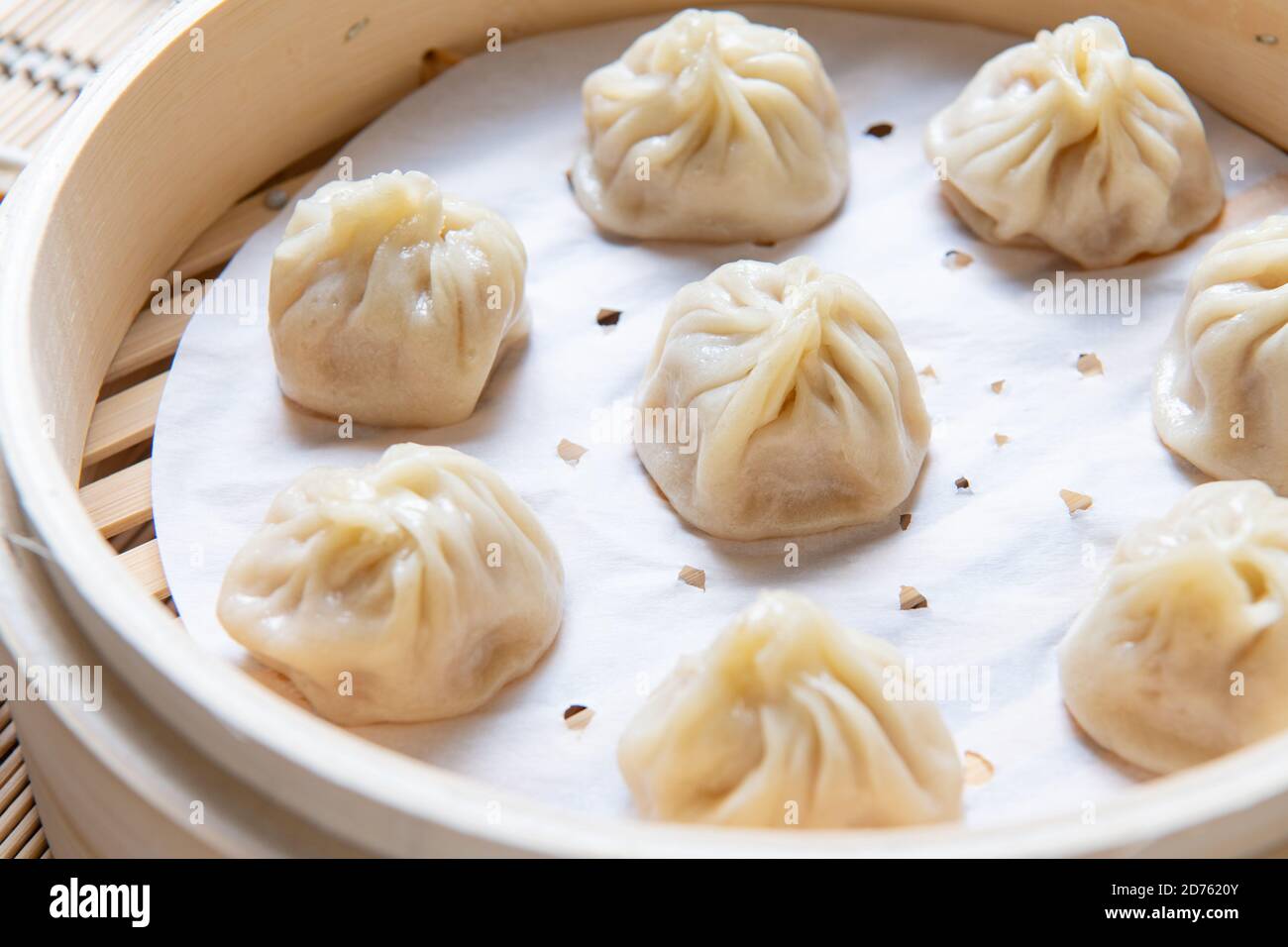 Gedämpftes Xiaolongbao in einem traditionellen Dampfkorb serviert Stockfoto
