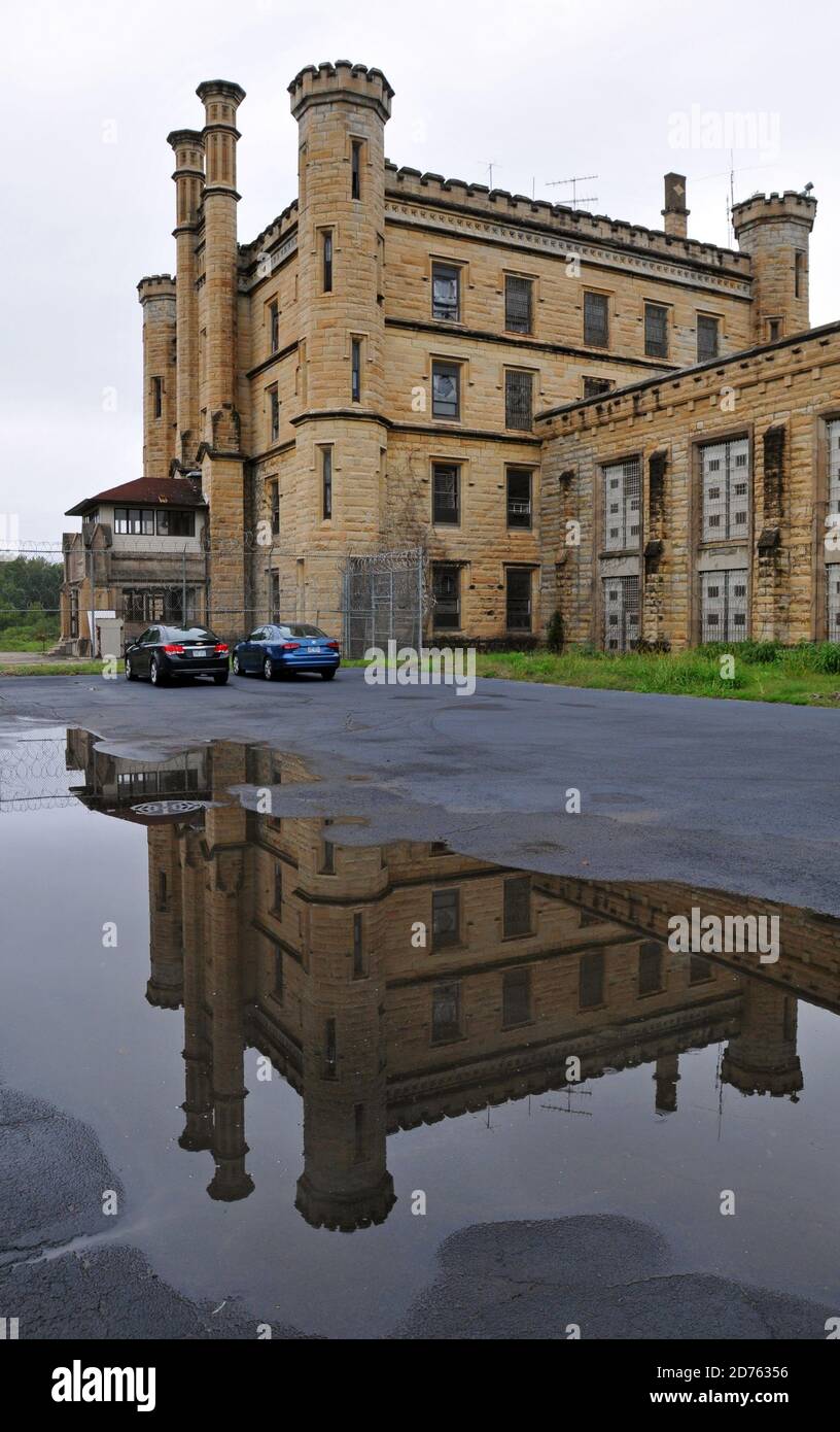 Die imposante Fassade des Alten Joliet Gefängnisses spiegelt sich in einer Pfütze wider. Die historische Stätte wurde 1858 eröffnet, bis 2002 betrieben und ist heute für Führungen geöffnet. Stockfoto