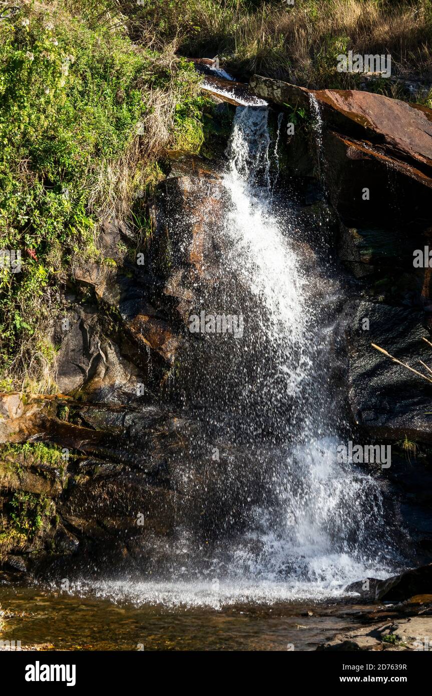 Kristallklares Wasser, das über die Felsformationen des Mato Limpo Wasserfalls spritzt, umgeben von grüner Vegetation. Cascade in Cunha, Sao Paulo - Brasilien. Stockfoto