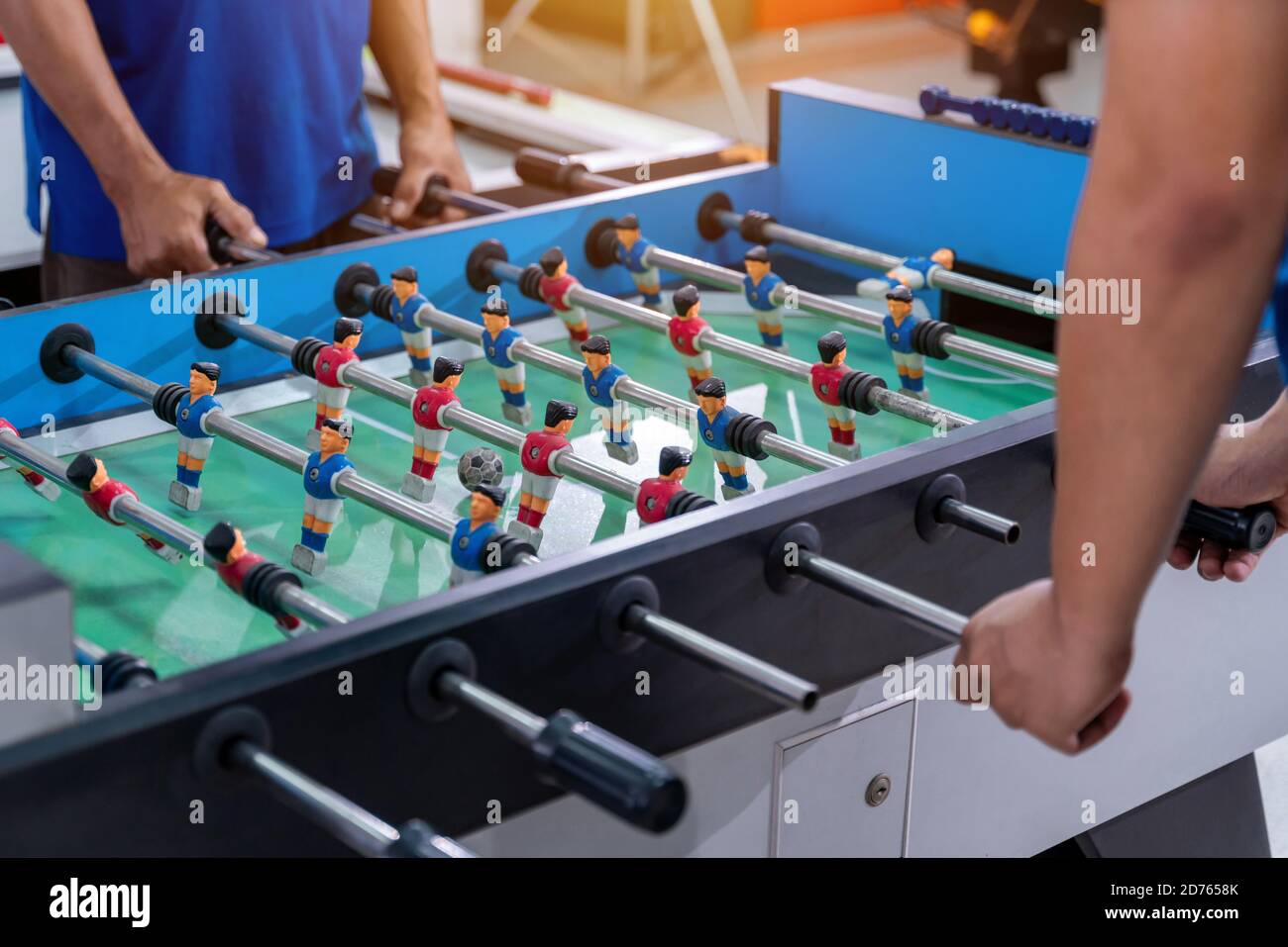 Büroangestellte spielen ein Hallenfußball-WM-Spiel während ihrer Pause Zeit, um Stress in der Freizeit zu lindern, Fußball-Tisch Mini-Spiel Stockfoto