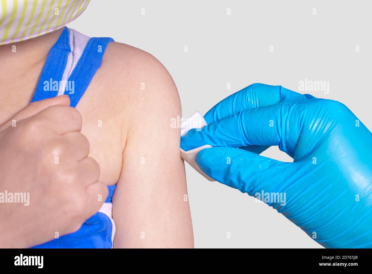 Kleiner Junge trägt Gesichtsmaske und bekommt einen Impfstoff. Stockfoto