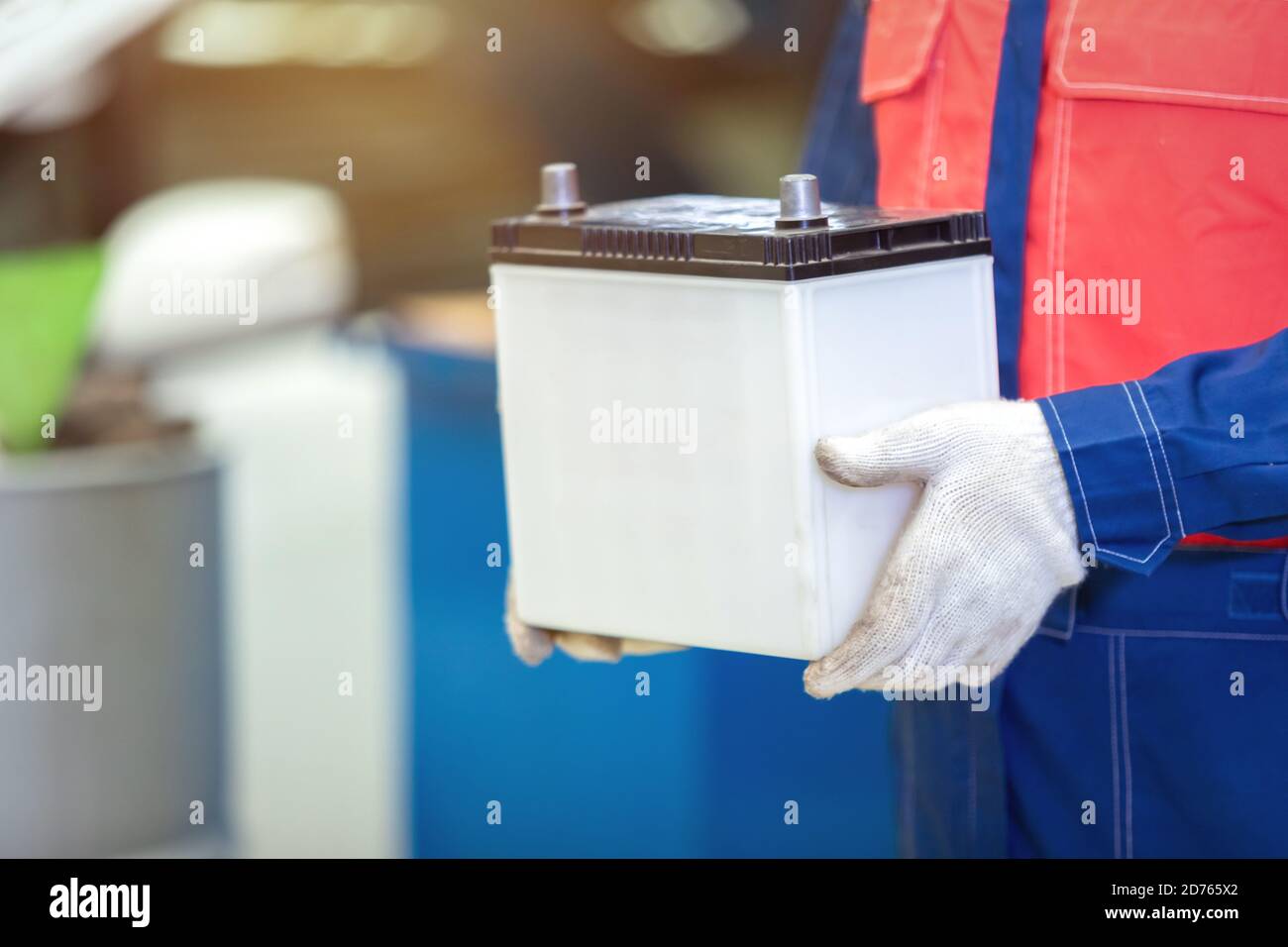 Nahaufnahme Handtechniker oder Automechaniker halten die Autobatterie in Auto-Reparatur-Service-Center. Stockfoto