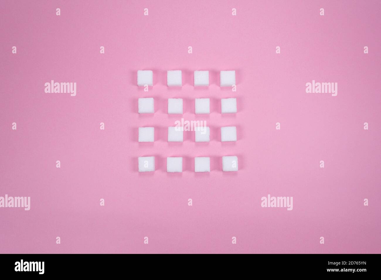 Weiße Zuckerwürfel auf rosa Hintergrund Zusammensetzung. Stockfoto
